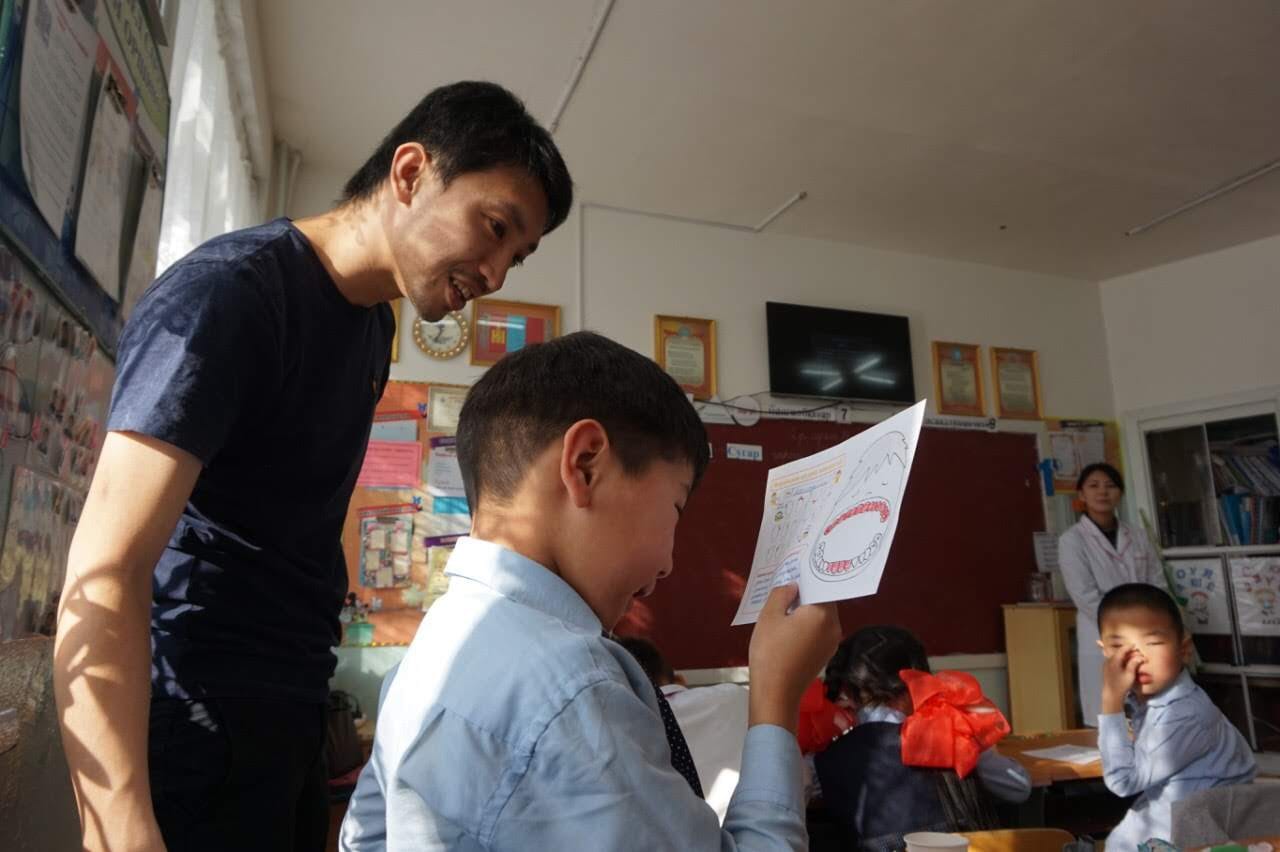 子どもの作品をのぞきこむ大石さん